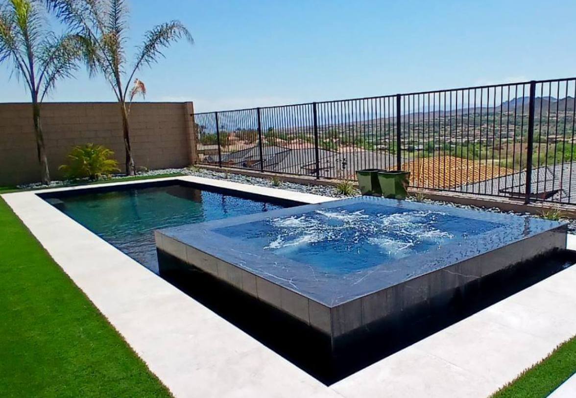 Rectangular pool surrounded by green, clean cut grass.